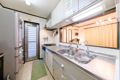 une cuisine avec un évier et un réfrigérateur dans l'établissement Hachioji - House - Vacation STAY 20638, à Haijima
