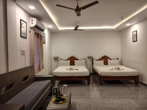 a room with two beds and a couch at The Hotel Eden Beach in Puducherry