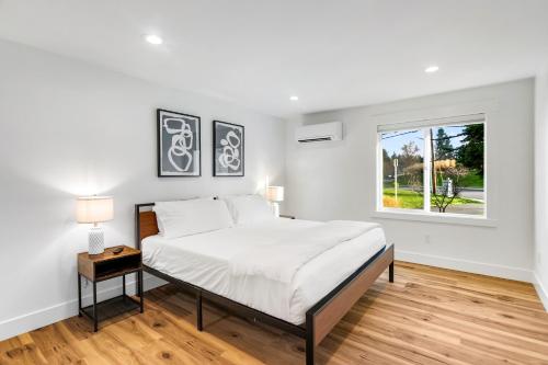 ein weißes Schlafzimmer mit einem großen Bett und einem Fenster in der Unterkunft Sunny 3BR Retreat Near Everett Waterfront in Everett