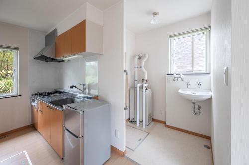 La cuisine est équipée d'un évier, d'un réfrigérateur et d'un évier. dans l'établissement Abutagun - House - Vacation STAY 86202v, à Usu