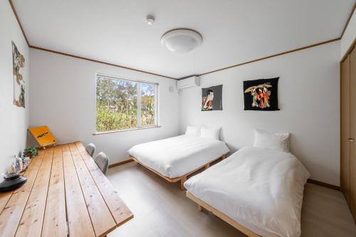 - 2 lits dans une chambre avec une table et une fenêtre dans l'établissement Abutagun - House - Vacation STAY 86202v, à Usu