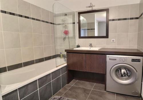 ein Badezimmer mit Waschbecken und Waschmaschine in der Unterkunft Appartement Cosy in Le Crès