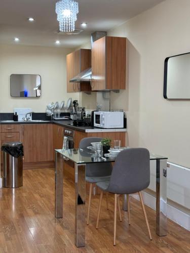 eine Küche mit Glastisch und Mikrowelle in der Unterkunft Nexus - Top Floor City Views, Balcony & Parking in Birmingham