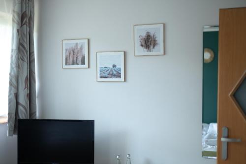 a living room with three pictures on the wall at Oberża in Czeladź