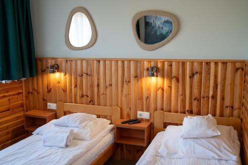 a bedroom with two beds and a mirror at Oberża in Czeladź