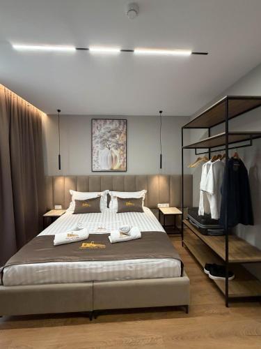 a bedroom with a large bed and a rack of clothes at Hotel Castle View in Krujë