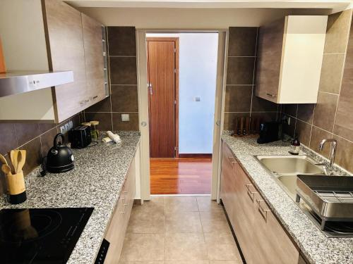 a kitchen with a sink and a counter top at Tipanie- Great 1bedroom in PPT, AC w pool & open view in Papeete