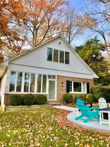 a house with a blue bench in the yard at Annapolis Charm Waterfront Getaway Near USNA - FISH & CRAB from your PRIVATE PIER! in Annapolis