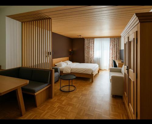 a hotel room with a bed and a couch at Haus Wenger Mountain View & Swimming Pool in Kaprun