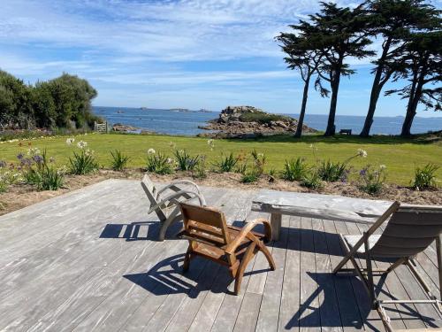 einen Tisch und zwei Stühle auf einer Terrasse mit Meerblick in der Unterkunft Maison de callot vue imprenable sur la mer in Carantec