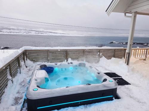 a hot tub covered in snow on a deck at Blabergan Lodge in Nord-Lenangen