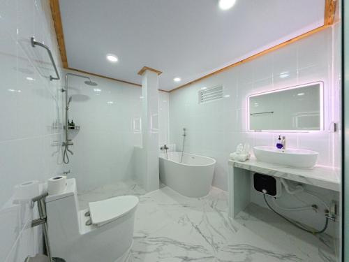 une salle de bain blanche avec toilettes et lavabo dans l'établissement Dacha Thoddoo White Sand, à Thoddoo