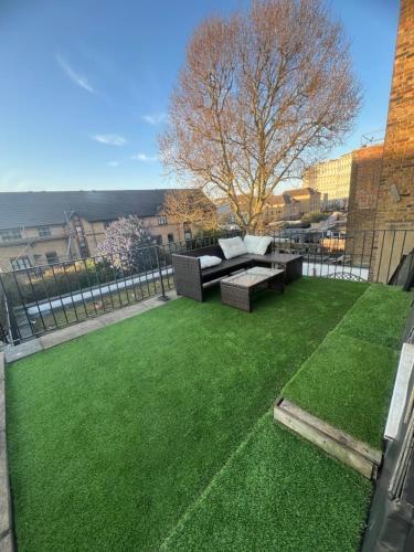 a garden with a couch and a grass yard at Plaza London Hotel in London