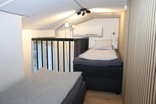 ein kleines Zimmer mit zwei Betten und einem Balkon in der Unterkunft Villa Rajaportti Loft with lake view and free front door parking&electric car plugs in Tampere