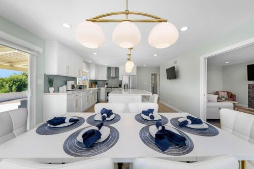 a dining room with a white table with blue hats on it at Family Hilltop luxe retreat with breathtaking views in La Mesa