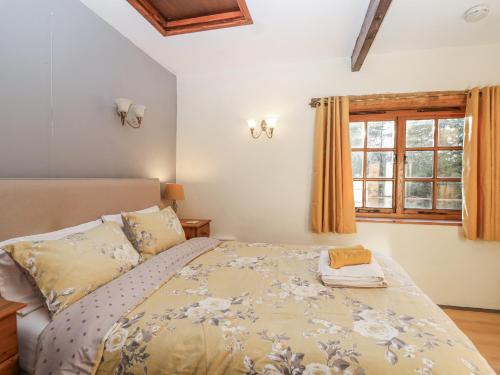 ein Schlafzimmer mit einem Bett und einem Fenster in der Unterkunft Miners Dry in Gunnislake