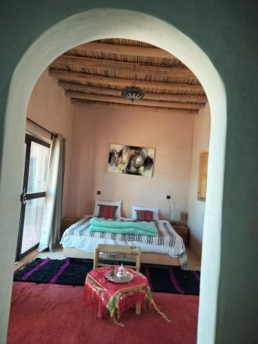 a bedroom with a bed and a table in a room at ITRANE Agafay in Marrakesh