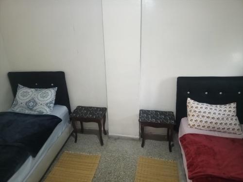 非斯KASBAH Guests Travel的一间客房配有两张床和两张带枕头的椅子。