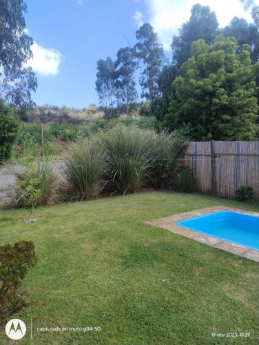 a backyard with a swimming pool and a fence at Los nogales in Tandil