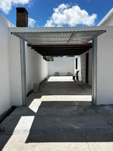 un patio con un banco bajo un edificio blanco en Chuy Aparts 2, en Chuy