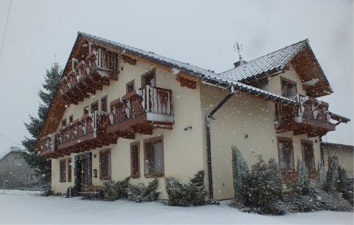 ein großes Haus mit Schnee auf dem Dach in der Unterkunft Pokoje Gościnne VEIKSME in Bestwina