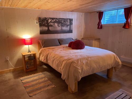 een slaapkamer met een bed met een teddybeer erop bij La forêt nourricière in La Tuque