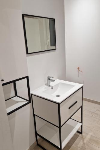 a white bathroom with a sink and a mirror at Maison 2 chambres proche circuit 24h et toutes commodités in Arnage