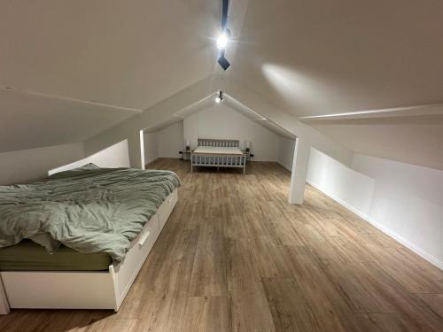 ein Dachgeschoss-Schlafzimmer mit einem Bett und einer Bank darin in der Unterkunft Serenity Briolance in Blanquefort-sur-Briolance