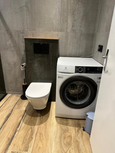 a bathroom with a washing machine and a toilet at Serenity Briolance in Blanquefort-sur-Briolance