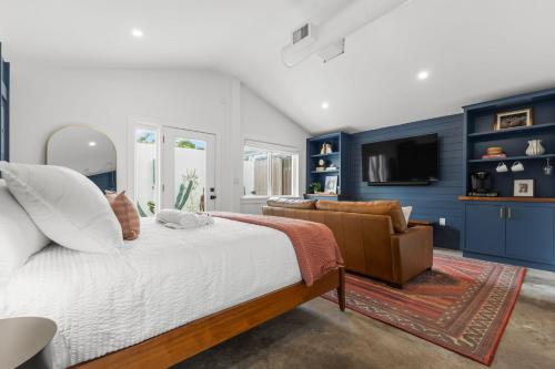 a bedroom with blue walls and a bed and a couch at La Casita - Steps from 7th Ave in Tampa
