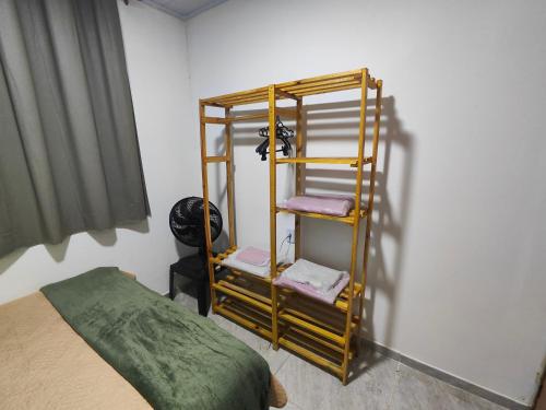 a room with a bed and a shelf with towels at Aconchego Terramar in Cabo Frio