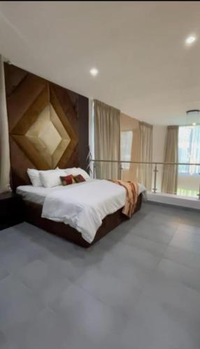 a bedroom with a large bed with a wooden headboard at Emerald harbor apartments in Lekki