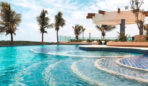 ein Swimmingpool mit Palmen und einem Gebäude in der Unterkunft Salinas Park Resort in Salinópolis