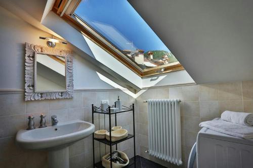 a bathroom with a sink and a skylight at Casa Al Prato Apt. F in Varenna