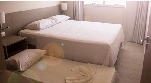 2 Betten in einem kleinen Zimmer mit einem Tisch in der Unterkunft Salinas Park Resort in Salinópolis