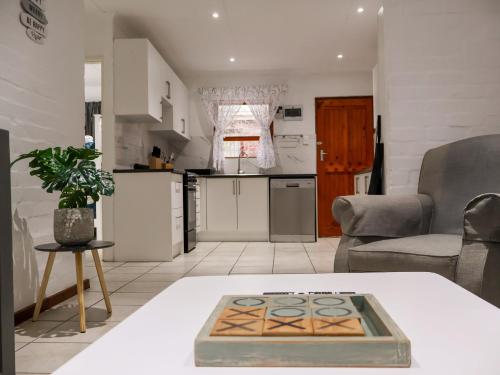 Gulls Nest في هيرمانوس: مطبخ وغرفة معيشة مع طاولة