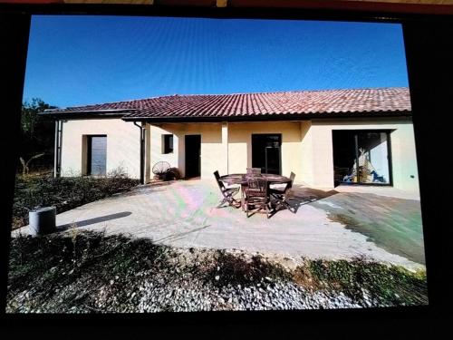 a table and chairs in front of a house at Viviloue in Saint-Pierre-Lafeuille