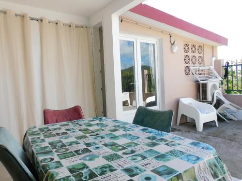 una stanza con tavolo, sedie e balcone di Tiny House, Tente Lodge & Suite, Le Paradis des Petits Voyageurs a Le Diamant