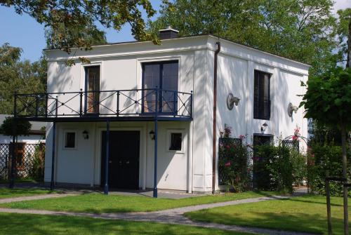 a white house with a porch and a balcony at Wunderschöne Wohnung In Swantow Mit Offenem Kamin in Poseritz