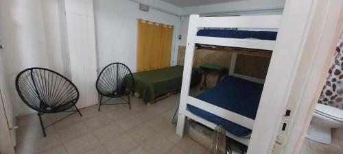 1 Schlafzimmer mit 2 Etagenbetten und 2 Stühlen in der Unterkunft BackPakersBasic in Tigre