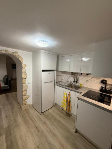 een keuken met witte kasten en een aanrechtblad bij Casa da Ti'nês in Bombarral