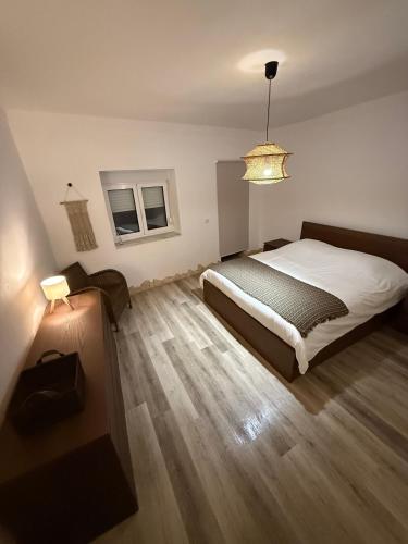 a bedroom with a bed and a chandelier at Casa da Ti'nês in Bombarral