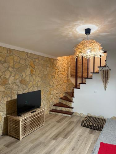 een woonkamer met een trap en een televisie bij Casa da Ti'nês in Bombarral