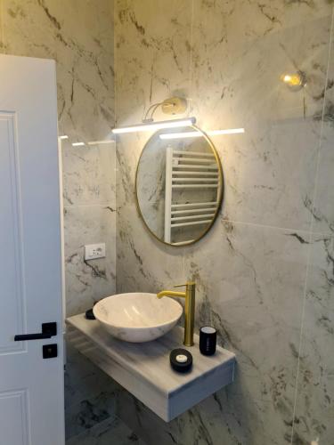 a bathroom with a sink and a mirror at Jolie Hotel in Craiova