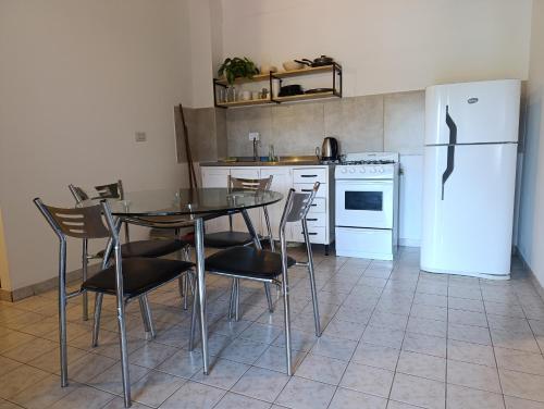 a kitchen with a table and chairs and a refrigerator at Numa Casa Temporal in Eldorado