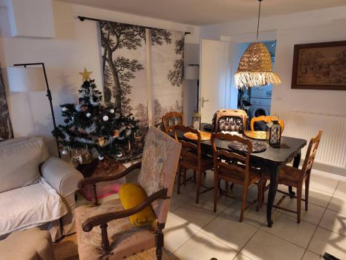 ein Wohnzimmer mit einem Tisch und einem Weihnachtsbaum in der Unterkunft The Cottage at 7 in Sainte-Foy-la-Grande