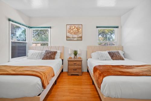 deux lits dans une chambre avec deux fenêtres dans l'établissement Hot Tub - Pool - FirePit - GameRoom - Sleeps 12!, à Riverside