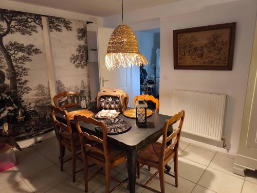 einen Esstisch mit Stühlen und einem Kronleuchter in der Unterkunft The Cottage at 7 in Sainte-Foy-la-Grande