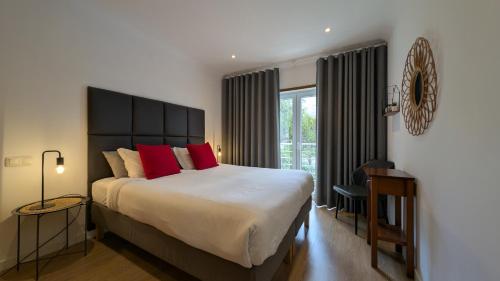 ein Schlafzimmer mit einem großen Bett mit roten Kissen in der Unterkunft Pine Tree Apartments - Praia da Coelha - Albufeira in Albufeira