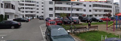 un parcheggio con auto parcheggiate di fronte a un edificio di Apartament Royal a Şelimbăr